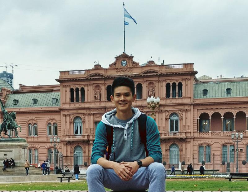 Toan sitting in front of a famous building